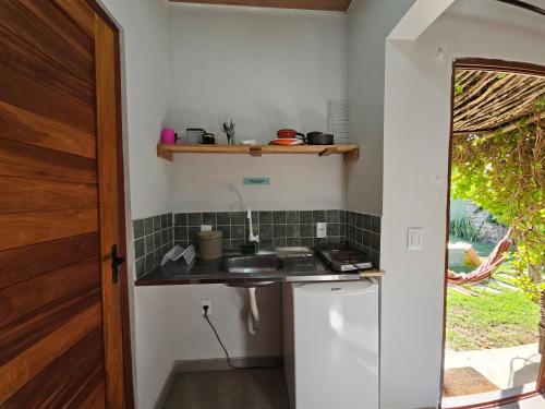 a small kitchen with a sink and a counter at Zero Meia Um Pousada in São Miguel do Gostoso