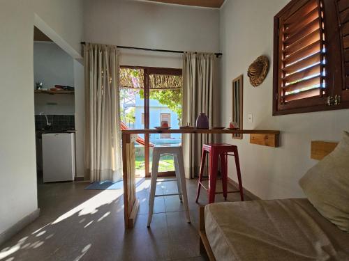 a kitchen with a table and two stools in a room at Zero Meia Um Pousada in São Miguel do Gostoso