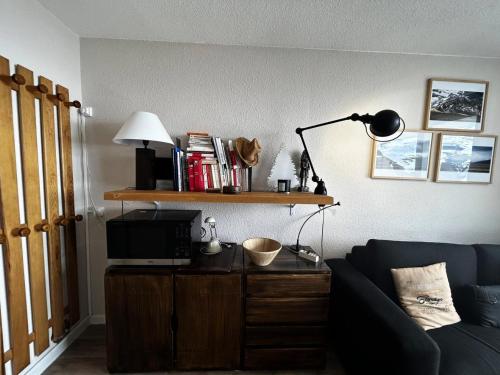 un salon avec un canapé bleu et une lampe dans l'établissement Résidence Combes - Studio 3 personnes à Brelin MAE-6044, aux Menuires