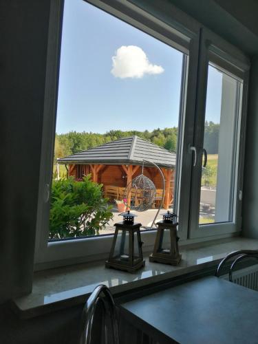 a window with a view of a log cabin at Agroturystyka Szklana Polana in Huta Szklana
