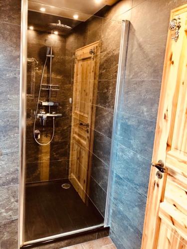a shower with a glass door in a bathroom at Little Blue Cottage #7 in Fehmarn