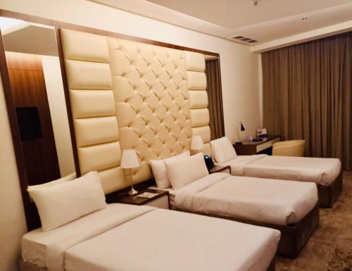 a hotel room with two beds and a couch at Dolphin Continental Hotel in Kuwait