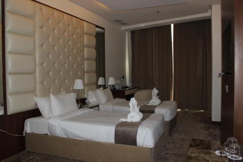 a hotel room with two beds with white cats on them at Dolphin Continental Hotel in Kuwait