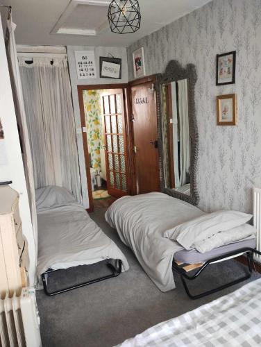 a bedroom with two beds and a mirror at North Edinburgh - Shared house bwith own room and bathroom in Edinburgh
