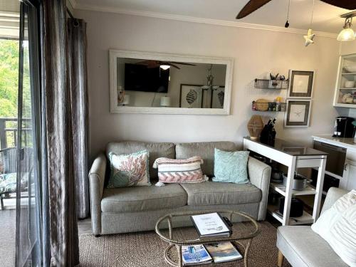 a living room with a couch and a mirror at Sunset Dunes Direct Beach Access in Hilton Head Island
