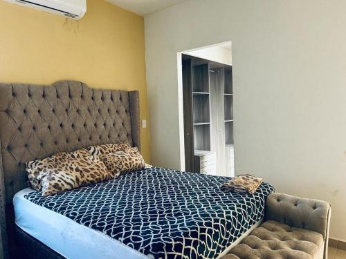 a bedroom with a bed with a blue comforter and a window at Casa del Lago in Veracruz