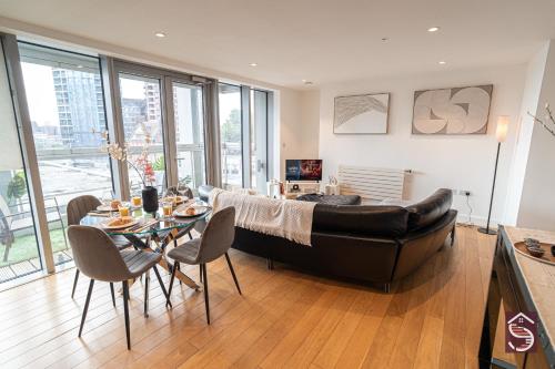 a living room with a couch and a table with chairs at The Canning Comfort in London