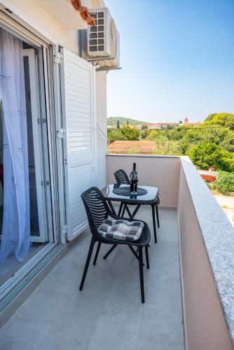 a patio with a table and chairs on a balcony at Apartmani Natalija 4 Stars in Mrljane