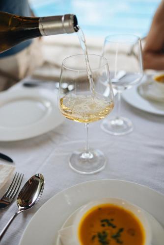a glass of wine on a table with a plate of soup at Can Moio Turismo de Interior in Montuiri