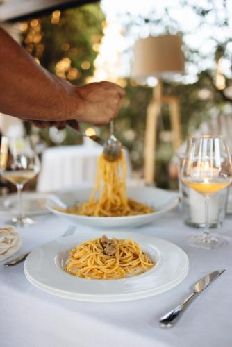a person sprinkling sauce on a plate of spaghetti at Can Moio Turismo de Interior in Montuiri