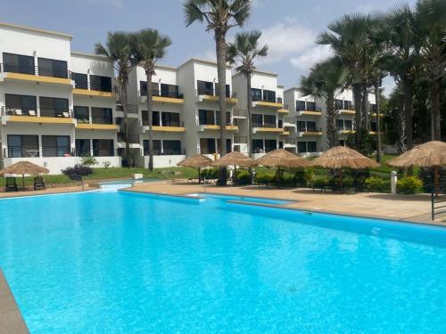 a large blue swimming pool in front of a building at WATERFRONT FLAT 4 BEDROOM in Kololi