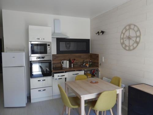 d'une cuisine avec une table et des chaises jaunes. dans l'établissement les volets bleus, à Lamalou-les-Bains