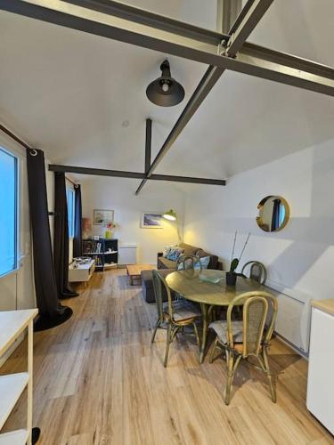 un salon avec une table et un canapé dans l'établissement Maisonnette à Batz sur Mer centre 8min des plages à pieds, à Batz-sur-Mer