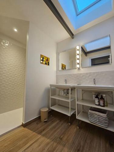 une salle de bain avec un lavabo et un miroir dans l'établissement Maisonnette à Batz sur Mer centre 8min des plages à pieds, à Batz-sur-Mer