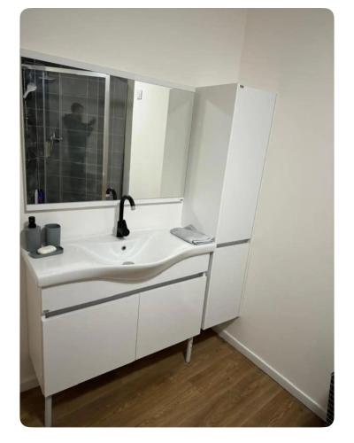 a white bathroom with a sink and a mirror at herseaux in Mouscron