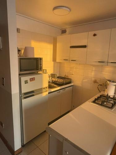 una cocina con nevera y microondas en Depto Concón frente a playa amarilla con gran vista al mar, en Concón