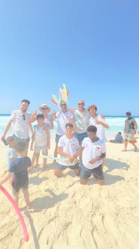 a group of people posing for a picture on the beach at Porto Matrouh unique Chalet in Marsa Matruh