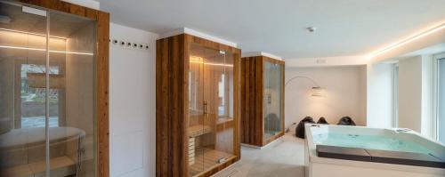 a bathroom with a tub and a glass shower at Maison de leon in Torgnon