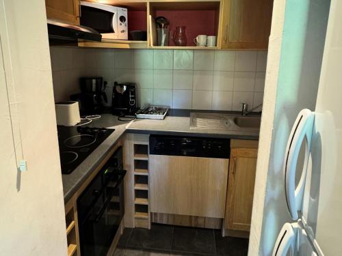 Il comprend une petite cuisine équipée d'une cuisinière et d'un évier. dans l'établissement Résidence Le Centaure - 2 Pièces pour 6 Personnes 601, à Aime La Plagne