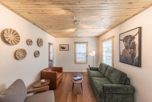 ein Wohnzimmer mit einem grünen Sofa und Holzdecken in der Unterkunft #StayinMyDistrict Brussels Bungalow in North Bend