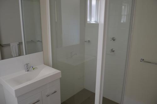 巴瑟斯特BATHURST GOLDFIELDS RESIDENCE on MOUNT PANORAMA的带淋浴和水槽的白色浴室