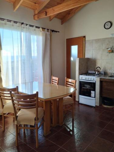 a kitchen with a table and chairs and a stove at La mata de calafate in El Calafate