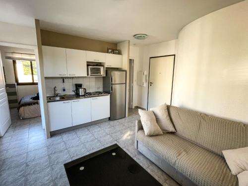 un salon avec un canapé et une cuisine dans l'établissement Cocon Riviera, à Cannes