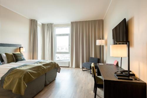 una camera d'albergo con un letto e una scrivania di Home Hotel Helma a Mo i Rana