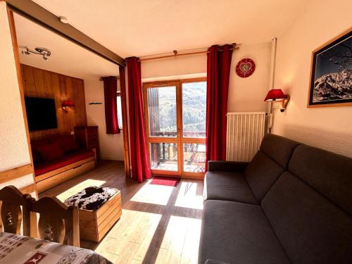 un salon avec un canapé et une fenêtre dans l'établissement Résidence Jetay - Appartement 4 personnes aux Ménuires avec vue sur la montagne MAE-5614, aux Menuires