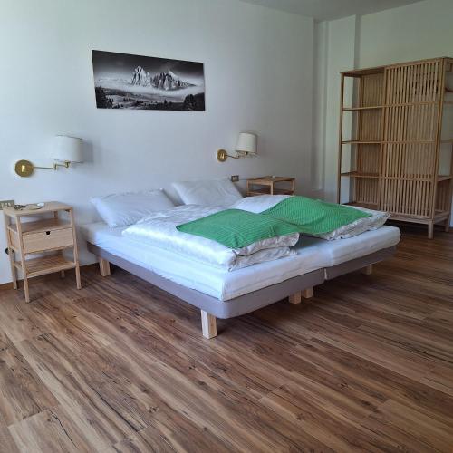 a bedroom with a large bed and a wooden floor at Chalet Center Pic in Ortisei
