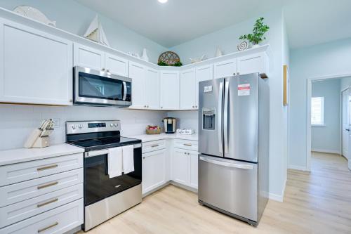 a kitchen with white cabinets and a stainless steel refrigerator at Waterfront Hudson Townhome with Dock Access! in Hudson