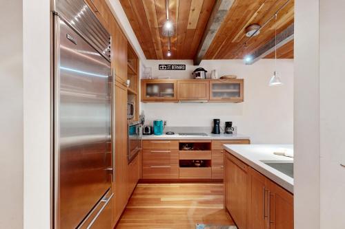 a kitchen with wooden cabinets and a stainless steel refrigerator at Predock 2A in Taos Ski Valley