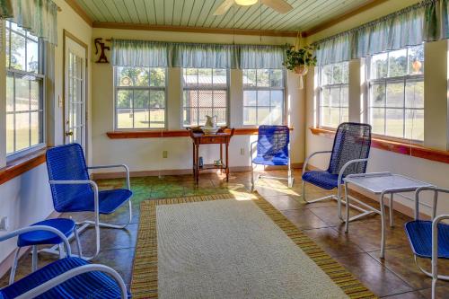 a room with blue chairs and a table and windows at Vintage Chipley Getaway on Large Private Property in Chipley