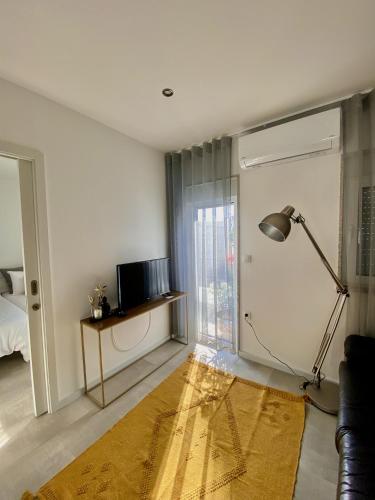 a living room with a couch and a lamp and a television at Casinha dos Carris in Valença