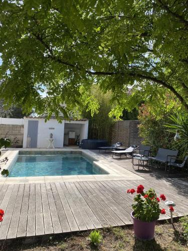 une cour arrière avec une piscine et une terrasse en bois dans l'établissement Villa Mathi, à Marseille