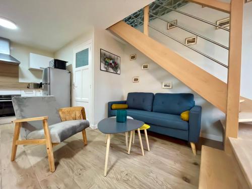 un salon avec un canapé bleu et une table dans l'établissement Un petit nid de paradis, à Pléneuf-Val-André