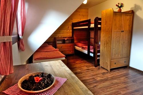 a room with two bunk beds and a table at Bačova drevenica in Liptovský Ján