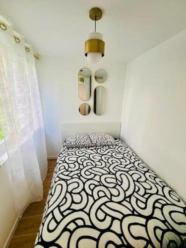 - une chambre avec un lit aux motifs noir et blanc dans l'établissement Joli appartement rénové incluant parking à 10 min de Paris, à Nanterre