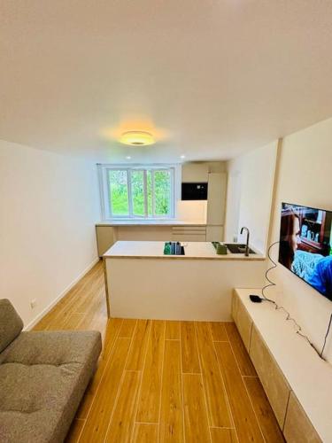 un salon avec un canapé et une cuisine dans l'établissement Joli appartement rénové incluant parking à 10 min de Paris, à Nanterre