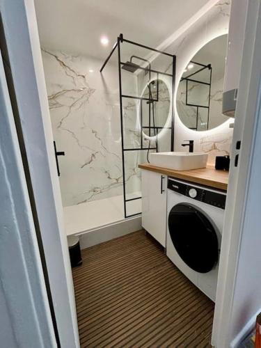 une salle de bain avec un lavabo et une machine à laver dans l'établissement Joli appartement rénové incluant parking à 10 min de Paris, à Nanterre