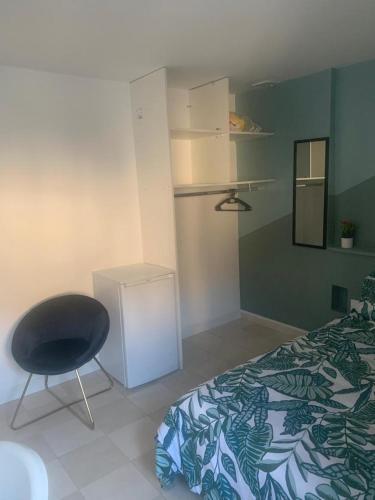 une chambre avec un lit et une chaise dedans dans l'établissement FOTOU Place, à Sarcelles