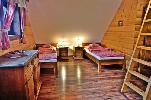 a room with two beds in a log cabin at Bačova drevenica in Liptovský Ján