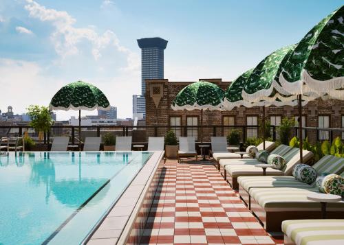 an outdoor pool on the roof of a building with lounge chairs at Memoir Warehouse District in New Orleans