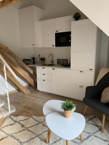 une cuisine avec des armoires blanches et une table dans une pièce dans l'établissement La Tour, à Léré