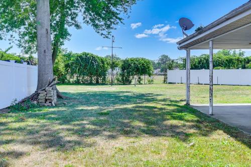 a tree in a yard next to a white fence at Long Island Duplex By Airport and Train in Valley Stream