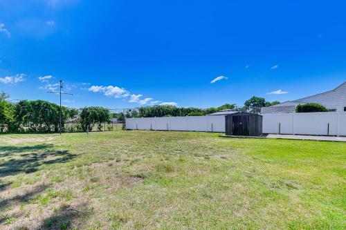 a large yard with a white fence and grass at Long Island Duplex By Airport and Train in Valley Stream