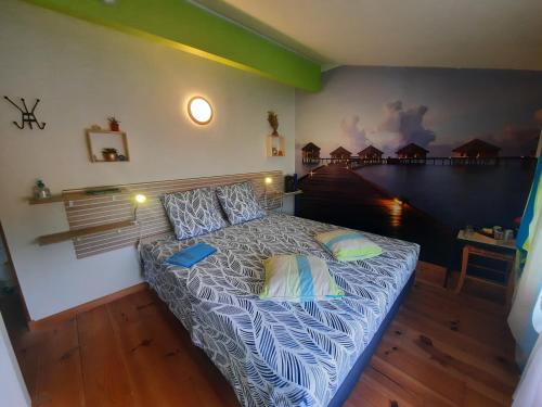 a bedroom with a bed with blue and white sheets at Chambre d'hôtes La Perla du Teich, piscine chauffée in Le Teich
