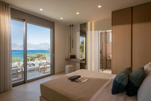 a bedroom with a large bed with a view of the ocean at Edem Boutique Hotel in Agios Nikolaos