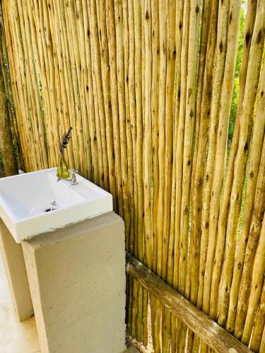 a bathroom with a sink and a bamboo wall at Elephant Corridor Lodge in Hluhluwe