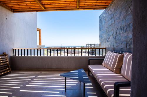 porche con sofá y mesa en el balcón en Luxury One Bedroom Apartment with Sea view in SomaBay, en Hurghada